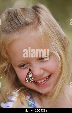 Gulf Fritillary (Agrulis vanillae), Mädchen mit Schmetterling, Hill Country, Central Texas, USA Stockfoto