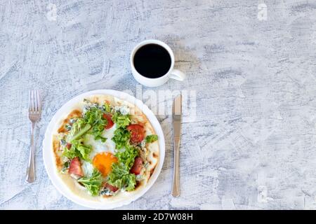 Italienisches Frühstück mit Kaffee. Piadina mit Ei, Tomaten und Salat. Köstliches Frühstück auf strukturiertem Tisch serviert. Draufsicht. Weichfokus Stockfoto