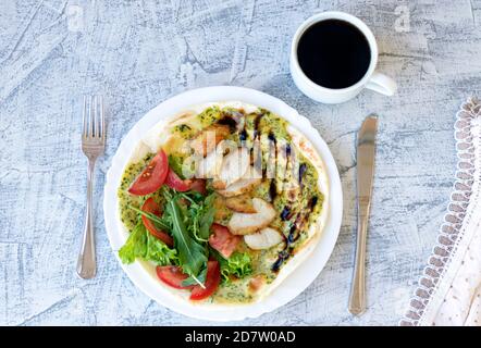 Italienisches Frühstück mit Kaffee. Piadina mit gegrilltem Hähnchen, Tomaten, Salat und Rucola. Köstliches Frühstück mit Serviette auf strukturiertem Tisch serviert. Weichfokus. Draufsicht Stockfoto