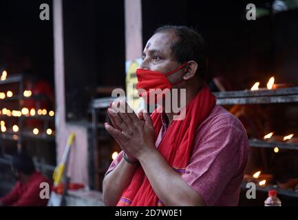 Hinduistische Anhänger bieten Gebete an, die Maske am Kamakhya Tempel während Navaratri Festival tragen, in Guwahati, Indien am Sonntag, 25 Oktober 2020. Kredit: David Talukdar/Alamy Live Nachrichten Stockfoto