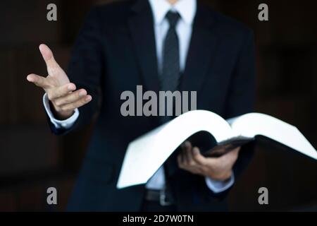 Zugeschnittenes Bild eines Rechtsanwalts, der ein Gesetzbuch hält Stockfoto