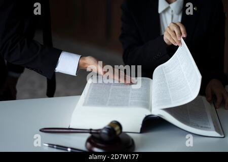 Anwälte diskutieren mit Gesetz Buch am Schreibtisch Stockfoto