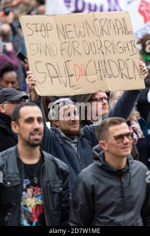 Ein Mann hält ein Protestplakat über ihrem Kopf während einer Anti-Lockdown-Kundgebung in London am 24. Oktober 2020 Stockfoto