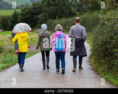 Familie geht für einen Landspaziergang in regnerisch und kalt Wetter Stockfoto