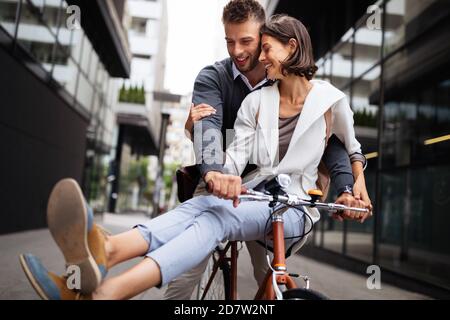 Porträt eines fröhlichen jungen Paares, das mit dem Fahrrad unterwegs ist und gemeinsam im Freien Spaß macht Stockfoto