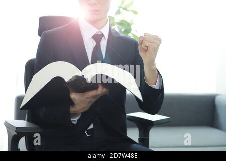 Rechtsanwalt hält die Faust mit dem Gesetzbuch. Chinesisches Zeichen 'beobbeon' bedeutet Code of laws, Gesetzbuch. Stockfoto