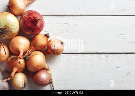 Gelbe und rote Zwiebeln auf weißem Holzgrund. Draufsicht. Stockfoto