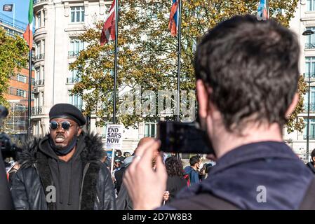 LONDON, ENGLAND - 25. OKTOBER: Protest gegen die SARS-Polizeieinheit wird in Marble Arch per Video interviewt. Britische Nigerianer protestieren gegen... Stockfoto
