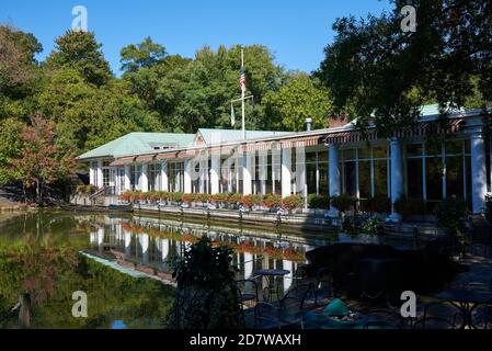 Das Loeb Boathouse spiegelt sich im stillen Wasser des Sees im Central Park, NYC an einem Tag mit einem klaren blauen Himmel. Stockfoto