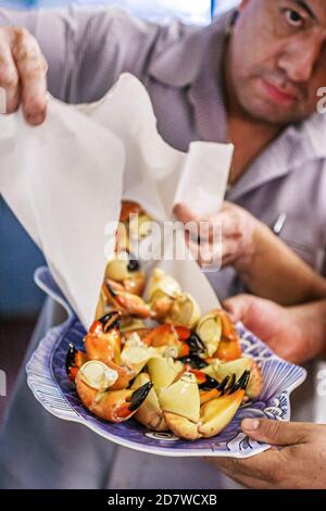 Miami Florida, Garcia's Seafood Grille & Fish Market, Restaurant Restaurants Steinkrabben Krallen Hispanic Mann männlicher Kellner, Stockfoto