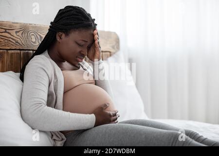 Coronavirus Und Schwangerschaft. Krank Schwarze Schwangere Frau Fühlt Sich Unwohl, Mit Covid-19-Symptome Stockfoto