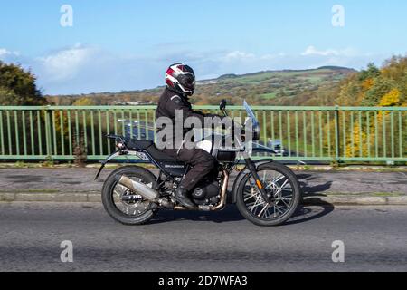 Ein Motorradfahrer, der mit einem Royal Enfield Himalayan über die M6-Brücke in Rivington bei Chorley in Lancashire, Großbritannien, fährt Stockfoto