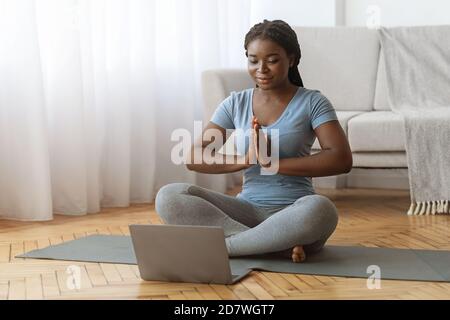 Online-Meditation. Black Lady Üben Yoga Vor Dem Laptop Zu Hause Stockfoto