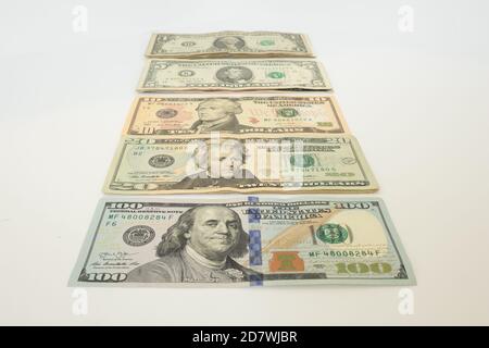 Verschiedene Werte von US-Dollar auf einer weißen Oberfläche angeordnet. Stockfoto