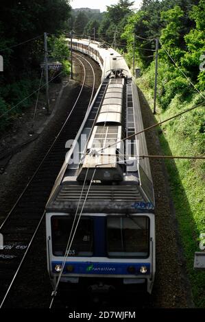 AJAXNETPHOTO. JUNI 2012. LOUVECIENNES, FRANKREICH. - RER-ZUG - S-BAHN OST NACH PARIS. IN WEITER FERNE, KNAPP ÜBER DER BAUMGRENZE, IST DAS ALTE AQUÄDUKT DE MARLY ZU SEHEN. ES WURDE IN EINEM LANDSCHAFTSGEMÄLDE VON ALFRED SISLEY AUS DEM JAHR 1872 MIT DEM TITEL "ROAD TO LOUVCIENNES" GEZEIGT, VON DEM ANGENOMMEN WIRD, DASS ES IN DER NÄHE DIESES ORTES GEMALT WURDE. FOTO: JONATHAN EASTLAND/AJAX REF:121506 2644 Stockfoto