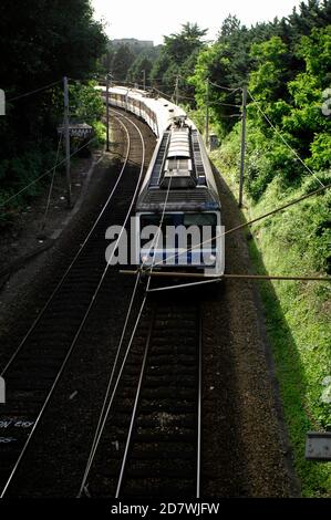 AJAXNETPHOTO. JUNI 2012. LOUVECIENNES, FRANKREICH. - RER-ZUG - S-BAHN OST NACH PARIS. IN WEITER FERNE, KNAPP ÜBER DER BAUMGRENZE, IST DAS ALTE AQUÄDUKT DE MARLY ZU SEHEN. ES WURDE IN EINEM LANDSCHAFTSGEMÄLDE VON ALFRED SISLEY AUS DEM JAHR 1872 MIT DEM TITEL "ROAD TO LOUVCIENNES" GEZEIGT, VON DEM ANGENOMMEN WIRD, DASS ES IN DER NÄHE DIESES ORTES GEMALT WURDE. FOTO: JONATHAN EASTLAND/AJAX REF:121506 2643 Stockfoto