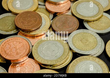 Verschiedene argentinische Münzen gestapelt. Haufen Geld. Metallmünzen Textur. Verschiedene Bezeichnungen. Stockfoto