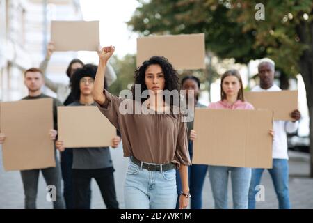 Aktive Frau, die eine Gruppe von Demonstranten auf der Straße führt Stockfoto