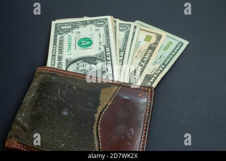Gebrauchte grüne und Leder Geldbörse mit amerikanischen Dollar bils isoliert Auf schwarzem Hintergrund Stockfoto