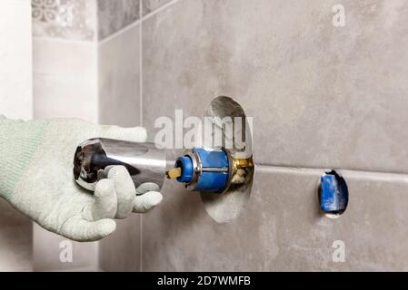 Die Hand des Arbeiters montiert einen eingebauten Wasserhahn. Stockfoto