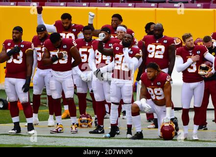 Landover, Usa. Oktober 2020. Mitglieder des Washington Football Teams knien und halten ihre ersten während der Nationalhymne vor einem NFL-Fußballspiel gegen die Dallas Cowboys auf dem FedEx Field in Landover, Maryland, am Sonntag, den 25. Oktober 2020. Foto von David Tulis/UPI Credit: UPI/Alamy Live News Stockfoto