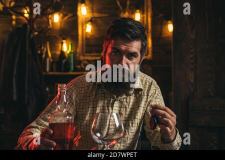 Schöner gestresster Geschäftsmann in formeller Kleidung mit einem Glas Whiskey und Autoschlüssel in der Hand. Depressive und hoffnungslose Menschen nach betrunken. Trauriger Mann Stockfoto