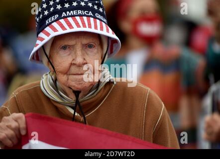 Ein Trump-Anhänger hält eine Flagge und trägt einen Keep America Great Hut während der Wahlkampfveranstaltung.EINIGE Anhänger von Präsident Donald Trump hielten eine 20 Mile Road Rally durch Luzerne County ab, die bis zur Wahl 2016 immer ein demokratischer starker Halt war, als sie überraschend zu Republikanern wechselte. Stockfoto