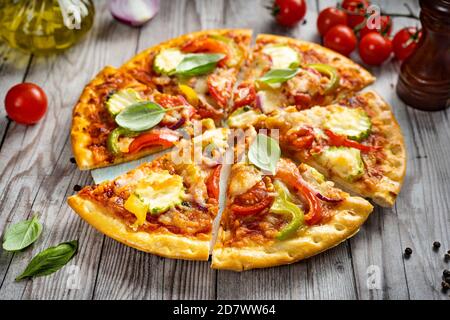 Scheiben vegetarische Pizza auf Holztablett und rustikalen Hintergrund Stockfoto