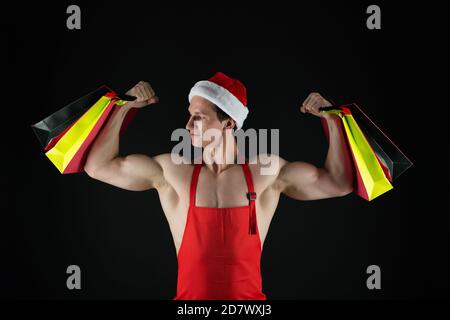 Fit weihnachtsmann halten Einkaufstaschen Beugen muskulösen Armen Bizeps Trizeps weihnachtsvorbereitung, stark. Stockfoto