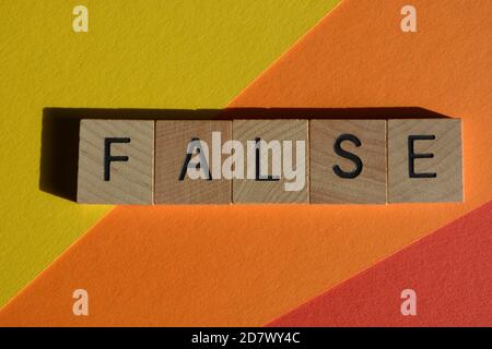 Falsch, Wort in hölzernen Buchstaben auf buntem Hintergrund isoliert Stockfoto