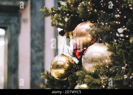 Festliche Outdoor dekorative weihnachtsbeleuchtung Hintergrund. Weihnachtsbaum Zweig mit Kugeln geschmückt, Kugeln auf architektonischen Wahrzeichen Hintergrund. Stockfoto
