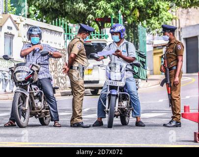 Colombo, Sri Lanka. Oktober 2020. Polizisten überprüfen Motorradfahrer in Wallampitiya in Colombo, Sri Lanka, am 25. Oktober 2020. Die Gesamtzahl der COVID-19-Fälle in Sri Lanka stieg am Sonntag auf 7,872, nachdem 351 neue Patienten entdeckt wurden. Quelle: Ajith Perera/Xinhua/Alamy Live News Stockfoto