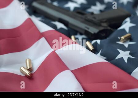 9 mm Kugeln und Pistole liegen auf gefalteter US-Flagge. Eine Reihe von Selbstschutzelementen oder ein spezielles Servicekit Stockfoto