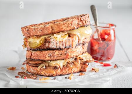 Rustikaler Toast mit Pilzen, Käse und Zwiebeln serviert mit bbq-Sauce Stockfoto