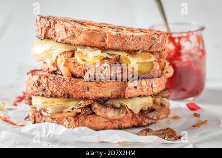 Ungesunder Toast mit Pilzen, Käse und Zwiebeln serviert mit bbq-Sauce Stockfoto