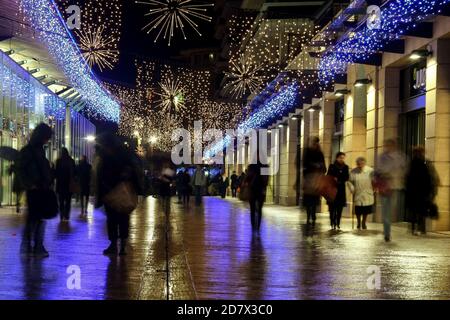 AIX EN PROVENCE, FRANKREICH - 28. NOVEMBER 2008: Verschwommene Menschen, die zwischen den Geschäften und Geschäften von Allees Provencales, der Haupteinkaufsstraße von Aix, spazieren Stockfoto