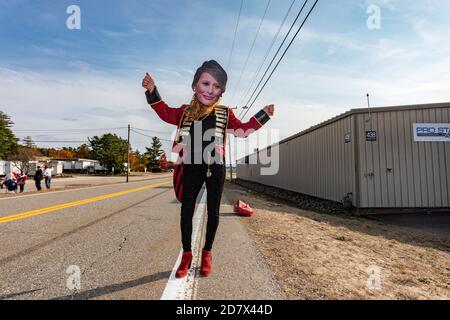 Londonderry, New Hampshire, USA. 25. Oktober 2020, Pro Star Aviation, Londonderry, New Hampshire USA: Ein Unterstützer von Präsident Donald Trump trägt eine Pappmaske von First Lady Melania Trump außerhalb seiner Wahlkampfveranstaltung bei Pro Star Aviation in Londonderry, N.H. Quelle: Keiko Hiromi/AFLO/Alamy Live News Stockfoto