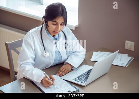 Indischer Telemedizin Arzt trägt Headset Gespräch mit dem Patienten per Online-Videoanruf. Stockfoto