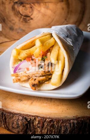 Griechischer Sandwich-Wrap mit Pita und pommes Frites Und Tzatziki und Huhn Stockfoto
