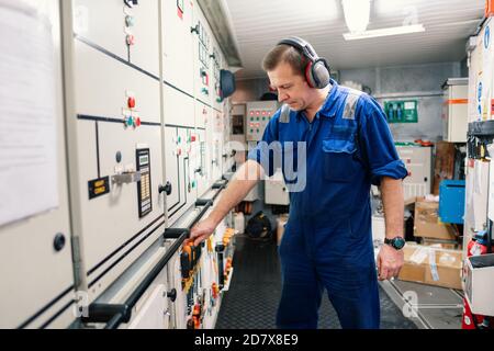 Marine Engineer Officer in Motorkontrollraum ECR. Er arbeitet in der Werkstatt Stockfoto