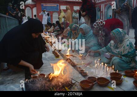 Pakistanische muslimische Anhänger zünden Kerzen und irdene Lampen am Schrein des berühmten Sufi-Heiligen Hazrat mir Mohammed Muayyinul aus dem 15. Jahrhundert während der 397. URS-Feierlichkeiten in Lahore an. Tausende von Menschen im ganzen Land besuchen den Schrein, um ihm während eines dreitägigen Festivals Tribut zu zollen.der heilige war unter den muslimischen und Sikh Religionen gleichermaßen beliebt, als Mian mir im Dezember 1588 nach Amritsar (Indien) ging, um den Grundstein für Sikhs heiligste Stätte, den Goldenen Tempel, zu legen. Die allgemein als Sri Harminder Sahib bekannt ist. (Foto von Rana Sajid Hussain/Pacific Press) Stockfoto