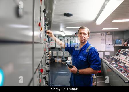 Marine Engineer Officer Steuerung von Schiffsmotoren und Antrieb in Motor Kontrollraum Stockfoto