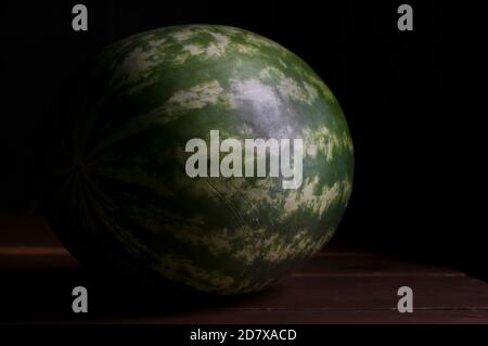 Chiaroscuro Stillleben Wassermelone auf einem Holztisch, barocker Renaissance-Stil Stockfoto