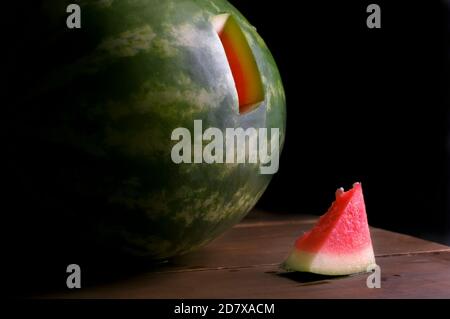 Spiking eine Wassermelone, Tests mit einer kleinen Probe von Wassermelone. Chiaroscuro Barockfotografie, Renaissance-Stil, Probe von Wassermelone. Stillleben Stockfoto