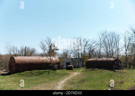 Zwei alte verlassene rostige Fässer liegen im Freien auf dem Gras. Stockfoto