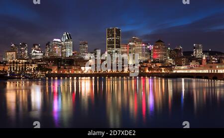 Skyline von Montreal beleuchtet bei Nacht mit schönen Reflexionen in Saint Lawrence River, Quebec, Kanada Stockfoto