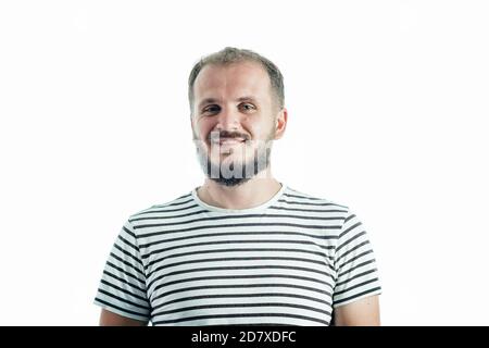 Lächelnder bärtiger reifer Mann in einem gestreiften T-Shirt. 30-35 Jahre alt. Isoliert auf Weiß. Stockfoto
