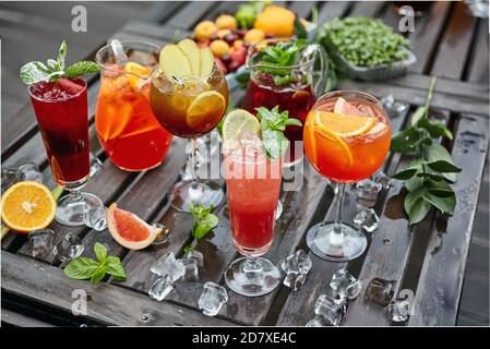 Cocktails in verschiedenen Farben auf einem Holztisch mit bedeckt Eis Stockfoto