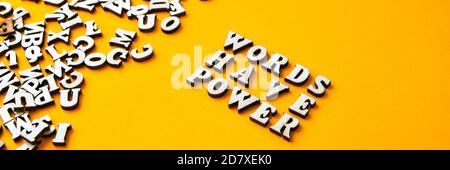 ZITATWÖRTER HABEN MACHT aus Holzbuchstaben auf hellgelbem Hintergrund. Stockfoto