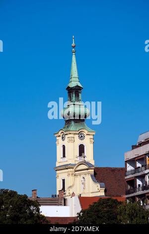 BUDAPEST, UNGARN - 16. JULI 2019: Uhrenturm und Kirchturm von St. Katharina von Alexandria Kirche Stockfoto